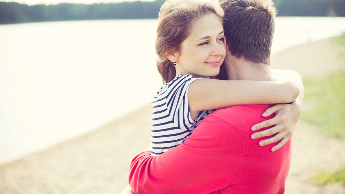 Teenage boy and girl hugging on beach