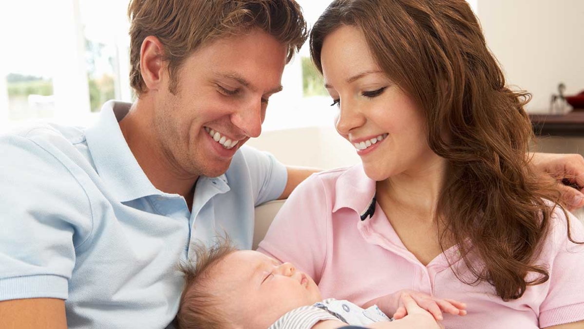 Couple smiling together with their baby